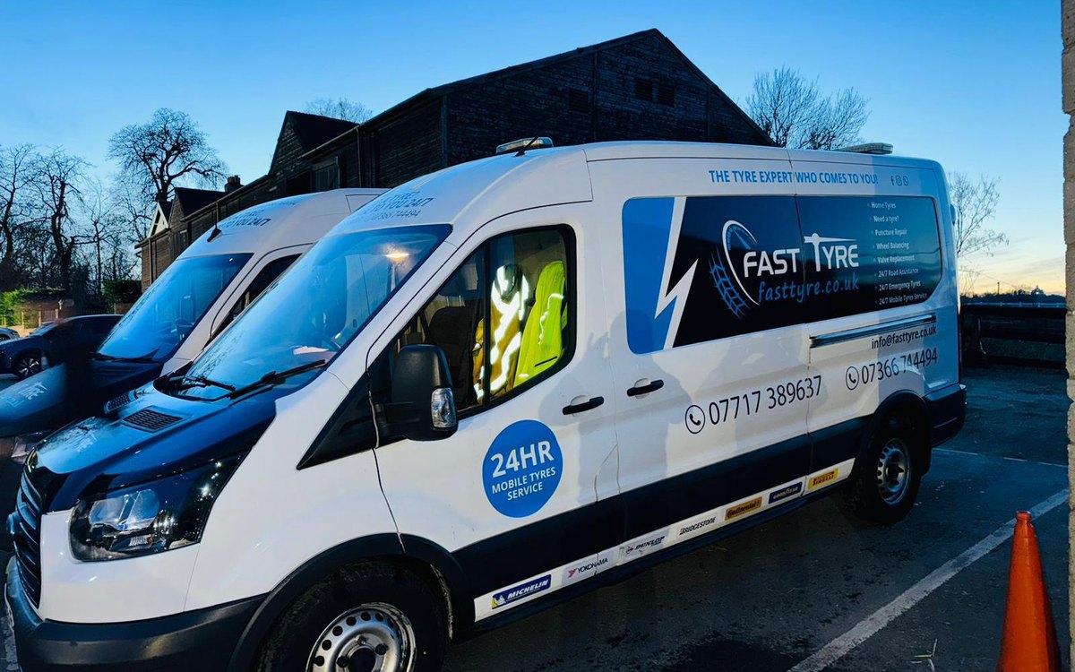A Fast Tyre van in full livery, its side door open on the job
